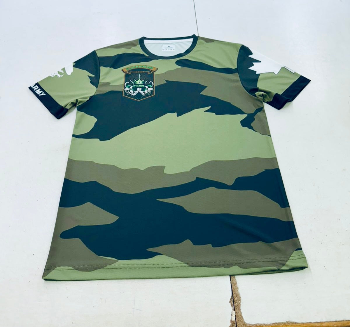 Camouflage-patterned shirt with a logo on a white background